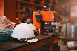 Weißer Schutzhelm mit Schutzhelm auf Werksgelände mit Kopierraum. Technik, Fabrikkonzept foto