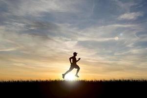 Running Man Silhouette im Sonnenuntergang. Silhouette für ein abendliches Läufertraining. Sonnenuntergänge foto