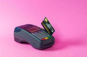 kreditkarte und kreditkartenscanner auf rosa hintergrund foto