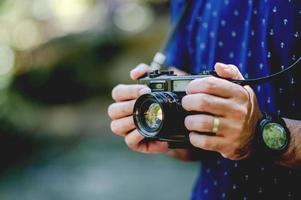 hand und kamera des fotografen reise in die berge und naturkonzeptfotograf foto