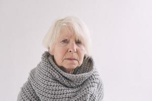 Seniorin im Schal zu Hause eiskalt. gesundheitsversorgung, krise, oldness-konzept foto