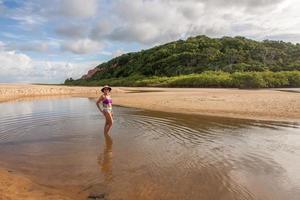 dame, die am strand steht, bekannt als taipe, in der nähe von arraial d ajuda, biaha, brasilien foto