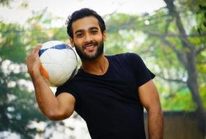 junger fußballspieler auf dem fußballplatz indisches mannbild foto