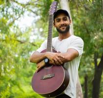 Junge brachte eine neue rote Gitarre foto