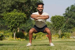 ein junger mann, der morgens im park scotts turnhalle trainiert - gesundheits- und fitnesskonzept foto