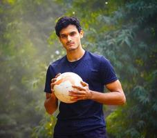 junger fußballspieler auf dem fußballplatz indisches mannbild foto