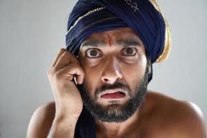 indischer mann im theater als könig verkleidet nicht glückliches gesicht foto