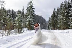 der bräutigam führt seine braut an der hand zu einer einsamen alten buche. Winterhochzeit. Platz für ein Logo. foto