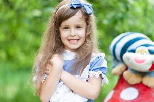 Porträt eines kleinen süßen Mädchens, das als Alice verkleidet ist. stilisiertes Fotoshooting in der Natur. foto