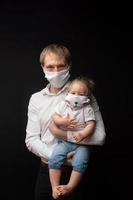 Der maskierte Vater hält seine kleine Tochter. Coronavirus-Schutzkonzept. foto