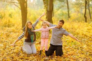 Familie, die im Herbstpark spazieren geht foto