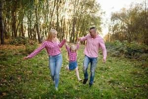 vater, tochter und mutter gehen im freien. glückliche Familie. foto