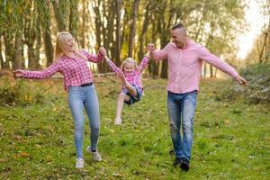 vater, tochter und mutter gehen im freien. glückliche Familie. foto