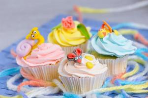 Viele Cupcakes liegen mit den Verzierungen auf dem Kopf foto