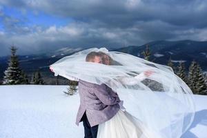 der bräutigam führt seine braut an der hand zu einer einsamen alten buche. Winterhochzeit. Platz für ein Logo. foto