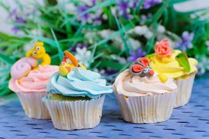 Viele Cupcakes liegen mit den Verzierungen auf dem Kopf foto