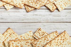 fröhliches Pessach-Konzept. Matza-Hintergrund. traditioneller jüdischer religiöser feiertag von pessach. Rahmen aus Matzenbrot auf einem weißen Holztisch. foto