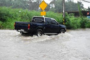 Pickup-Auto und Fahrzeug in Hochwasser, Autoversicherung und Konzept für Gefahrensituationen. foto