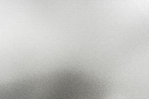 gebürstete silberne Metallwand mit zerkratzter Oberfläche, abstrakter Texturhintergrund foto