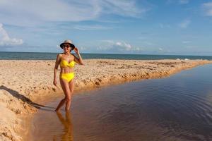 fitte frauen in einem gelben bikini am strand bekannt als pitinga, in arraial d ajuda, bahia, brasilien foto