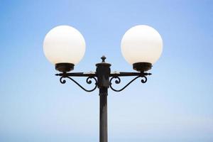 runde Lampe auf Stange, Außenbeleuchtung am klaren blauen Himmel. Fotos von weißen Laternen, die auf der Straße außerhalb der Residenz aufgenommen wurden.