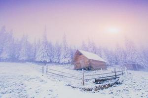 Sonnenuntergang in den Winterbergen und fantastisches Chalet foto