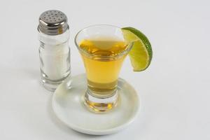Tequila mit Kalk auf dem weißen Hintergrund foto