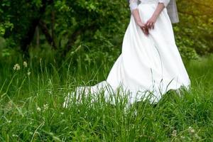 Hochzeitshintergrund, Braut in einem weißen Kleid auf grünem Hintergrund foto