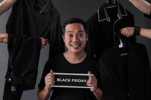 black friday verkaufsaktion mit shopaholic man model umgeben von schwarzer kleidung und man accessoires foto