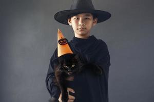 asiatischer junge mit seinem haustier, das halloween-kostüm trägt foto