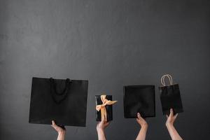 Ernte der Hand, die Einkaufstasche oder Goodie-Bag für Shopaholic-Online-Shopping-Hintergrund und Black-Friday-Promotion hält foto