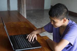 Der Junge beabsichtigt, in der Provinz online zu studieren. foto