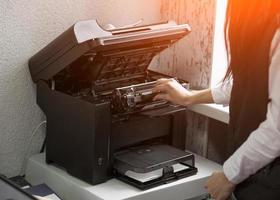 Büroangestellter wechseln die Patrone in einem Laserdrucker foto