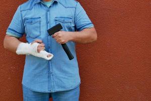 Männer mit vergipster Hand mit einem Hammer foto