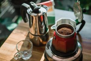 fein gemahlener kaffee und vintage kaffeemaschine moka pot auf holztisch zu hause, selektiver fokus. foto