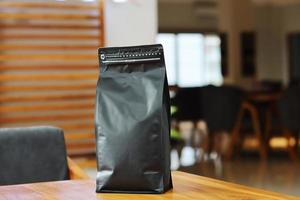 Foto einer Kaffeeverpackung, die Beutelgröße 1 kg auf dem Cafétisch steht. geeignet für Mock-up-Etikettenaufkleber, Verpackungsaufkleber für Kaffeevarianten usw.