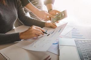 geschäftsteam analysiert verkaufsdaten und wirtschaftswachstumsdiagramm auf bürotisch mit laptop und smartphone, brainstorming, geschäftsstrategie und planung. foto