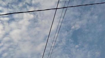elektrische Drähte und die Cirrocumulus-Wolken des blauen Himmels foto