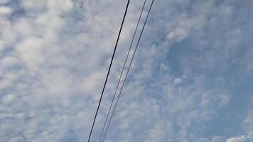elektrische Drähte und die Cirrocumulus-Wolken des blauen Himmels foto