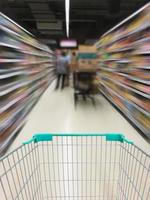 Blick auf einen Einkaufswagen und Gang im Supermarkt foto