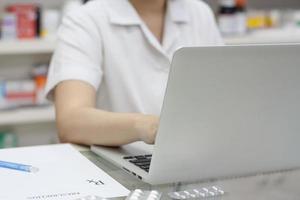 Apotheker mit Laptop-Computer und Medikamenten in der Apotheke foto