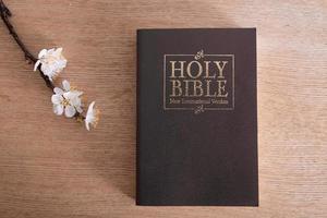 heilige bibel auf tischplatteansicht mit blühendem frühlingszweig foto