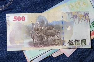 taiwanesisches Geld, taiwanesische Banknote, taiwanesischer Dollar auf Jeanshintergrund. foto