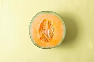 Draufsicht auf gelbe Melonenscheibe auf gelbem Hintergrund foto