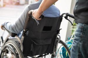Pflegekraft hilft und pflegt asiatische Senioren oder ältere Frauen, die im Rollstuhl auf der Krankenstation sitzen, gesundes, starkes medizinisches Konzept