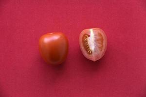 saftige Tomate auf rotem Hintergrund foto