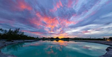 der Himmel nach Sonnenuntergang über dem smaragdgrünen Teich. Stratocumulus- und Altostratuswolken. foto