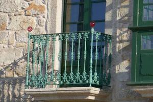 Grüner Eisenbalkon mit roten Glasdetails foto