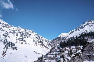 Lawinenverbauungen am schneebedeckten Berghang mit Bäumen foto