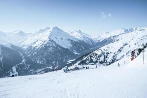 Skifahrer Skifahren auf schneebedeckten Berghang gegen den blauen Himmel foto